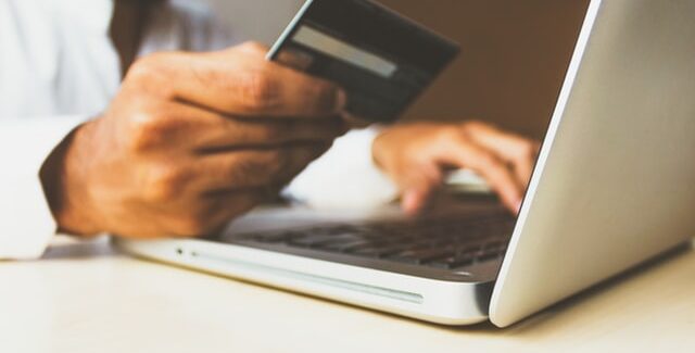 Landlord 101: Property management fees explained | HomeVault man with credit card wanting to pay using a laptop